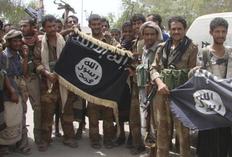 Army soldiers display flags of the al Qaeda-linked Ansar al-Sharia group, at a position recaptured from thr group near the southern Yemeni city of Zinjibar